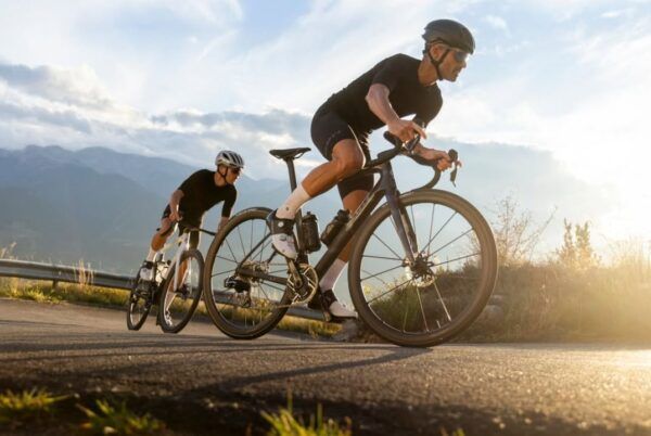 Dos ciclistas en una ruta montañosa bajo un cielo despejado