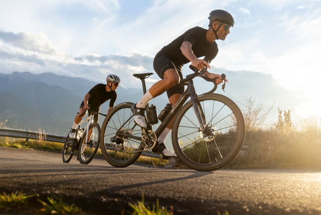 Dos ciclistas en una ruta montañosa bajo un cielo despejado