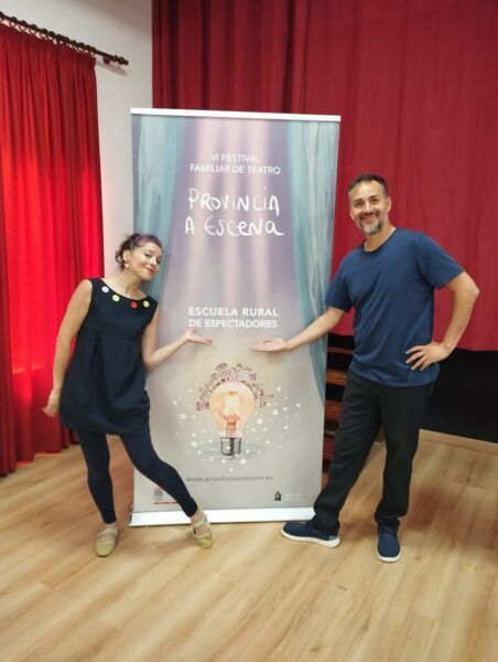Dos personas posando junto a un cartel del Festival Familiar de Teatro en Salamanca