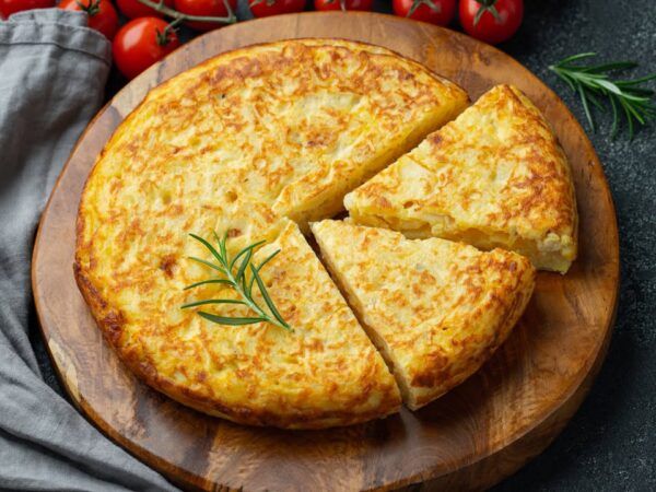 Tortilla de patatas cortada sobre una tabla de madera