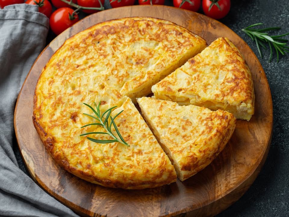 Tortilla de patatas cortada sobre una tabla de madera
