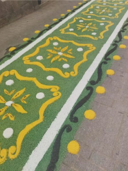Alfombra colorida elaborada con flores y materiales naturales