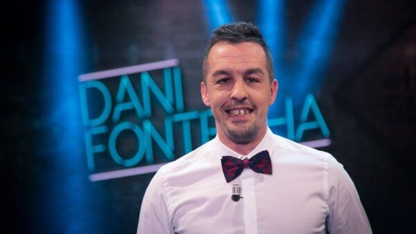 Dani Fontecha sonriendo con un pajarita en un escenario iluminado