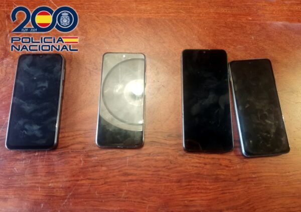 Cuatro teléfonos móviles robados en una mesa de madera