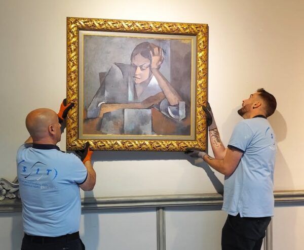 Dos personas colocando una pintura en el Museo Casa Lis de Salamanca