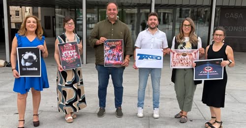 Grupo de personas sosteniendo carteles de eventos musicales en Guijuelo