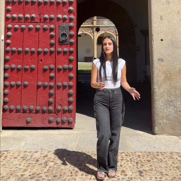 Joven hablando frente a una puerta roja en la Universidad de Salamanca