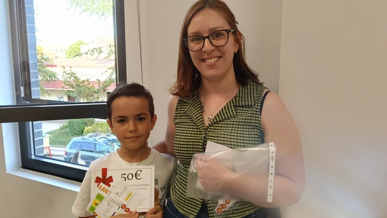 Niño y adulto sosteniendo premios del Lecturómetro de Baldosas Amarillas