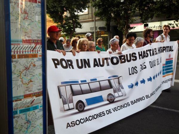 Manifestación por un transporte público digno en Salamanca con un grupo de personas sosteniendo un cartel.