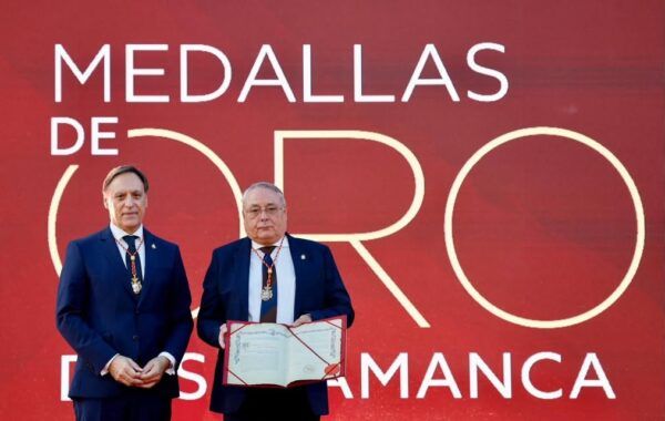 Dos hombres sosteniendo un documento en la ceremonia de la Medalla de Oro de Salamanca