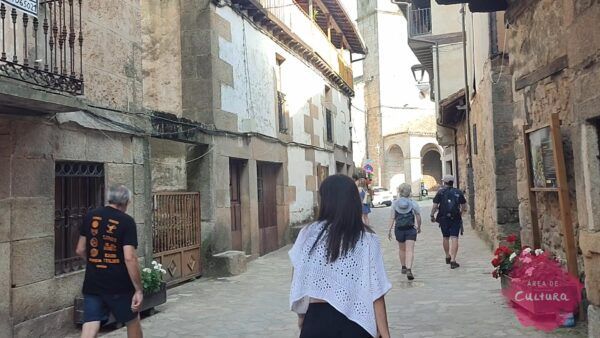 Personas caminando por una calle en San Martín del Castañar durante el festival