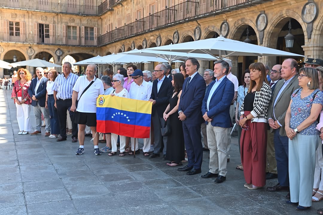 Grupo de personas en la Plaza Mayor de Salamanca con una bandera de Venezuela