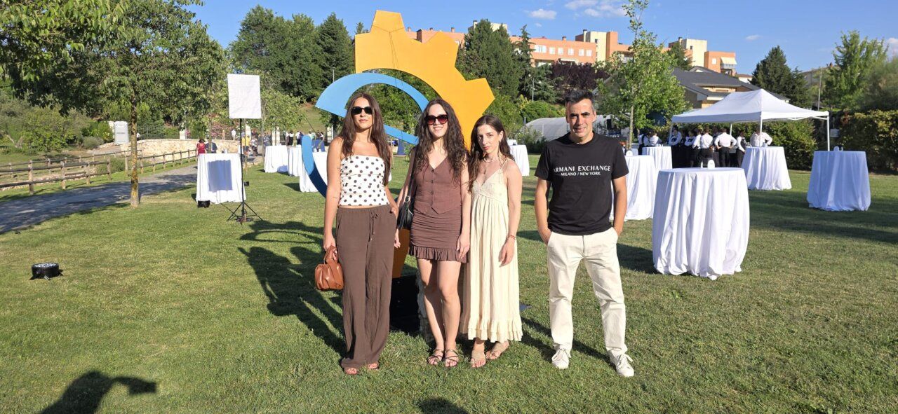 Grupo de cuatro personas posando en un evento al aire libre