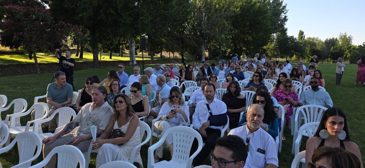 Asistentes sentados en un evento al aire libre