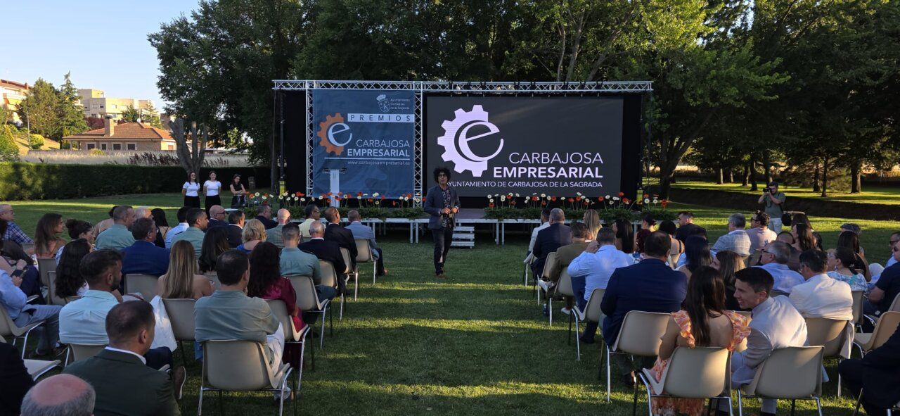 Ceremonia de los Premios Carbajosa Empresarial en un jardín con asistentes.