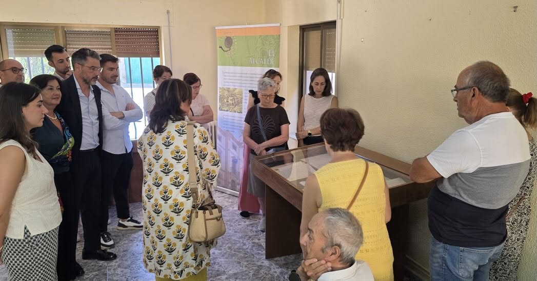 Grupo de personas observando una exposición sobre archivos en Topas
