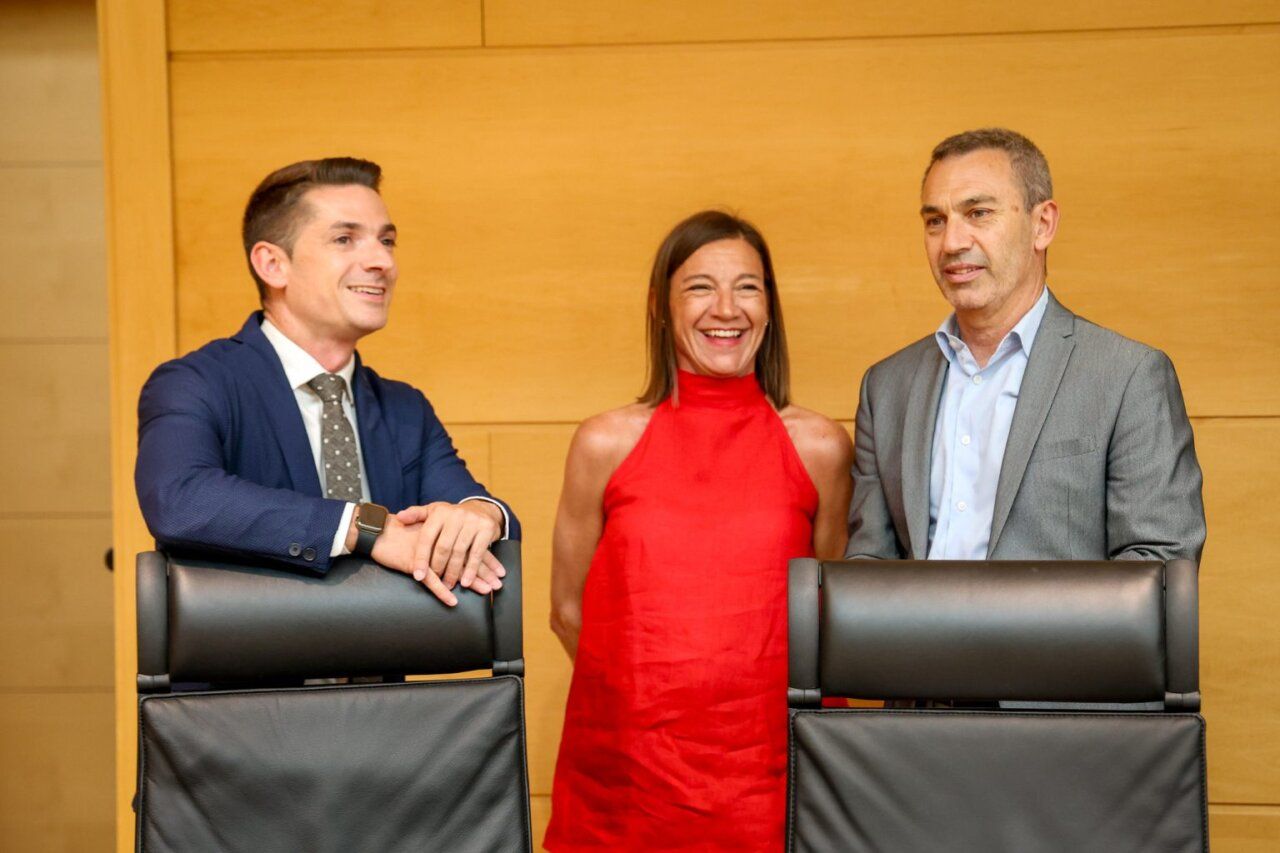 Tres personas sonriendo en una reunión sobre cultura y turismo