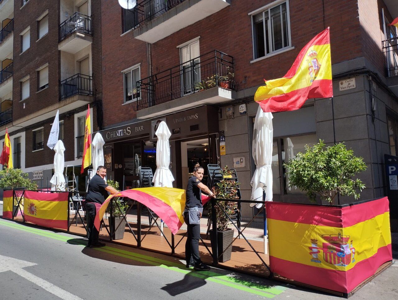 Personal del Café Bar Chinitas preparando decoración con banderas de España.