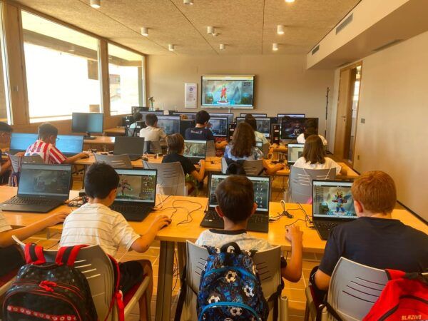 Niños participando en un campamento digital aprendiendo tecnología