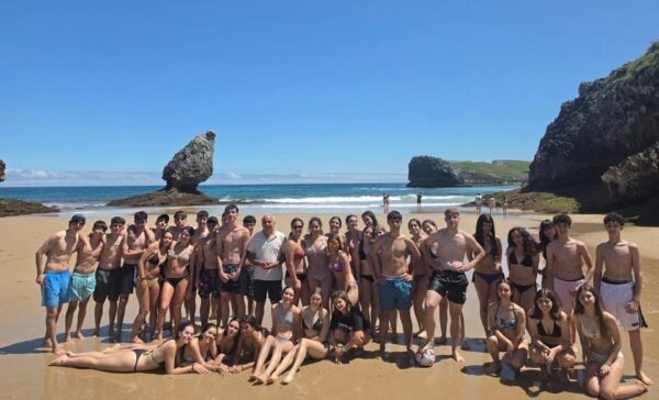 Grupo de jóvenes en la playa durante un campamento multiaventura en Asturias