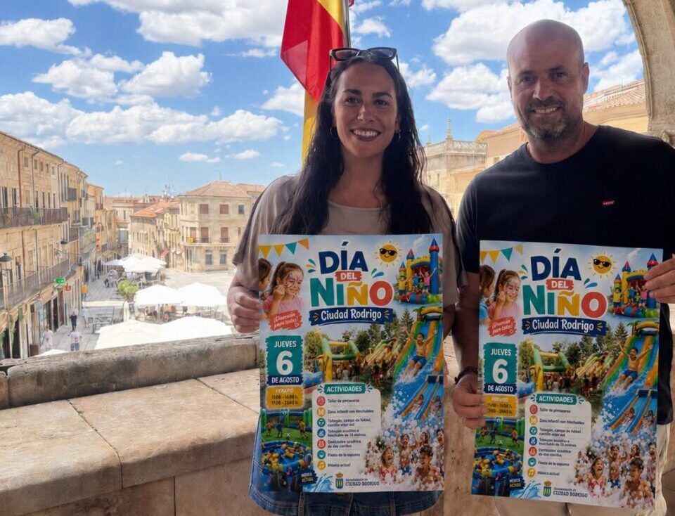 Dos personas sosteniendo un cartel del Día del Niño en Ciudad Rodrigo