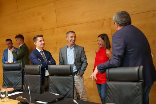 Reunión de la Comisión de Cultura, Turismo y Deporte con varios participantes conversando.