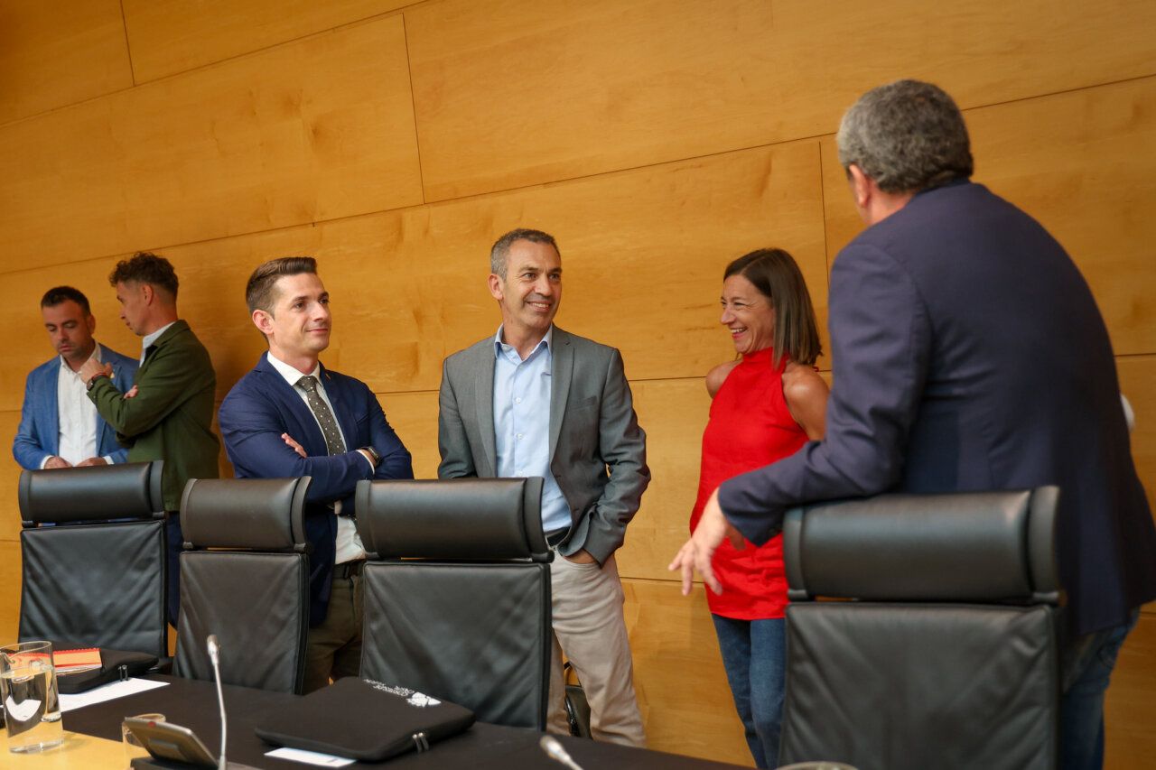 Reunión de la Comisión de Cultura, Turismo y Deporte con varios participantes conversando.