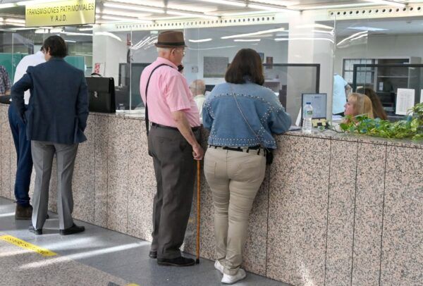 Personas en una oficina pública gestionando trámites administrativos