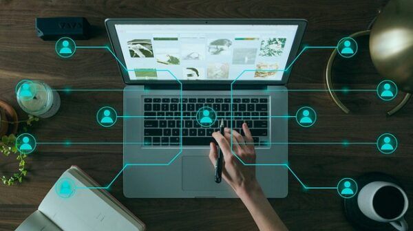 Persona trabajando en una laptop con gráficos y conexiones digitales