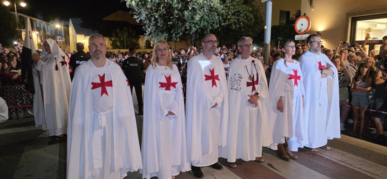 Participantes del desfile templario en Ponferrada con capas blancas y cruces rojas