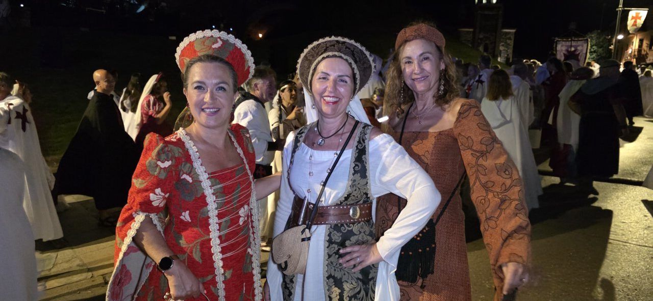 Tres mujeres vestidas con trajes tradicionales en un desfile templario