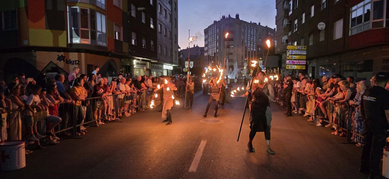 Participantes del desfile templario en Ponferrada con antorchas en la noche.
