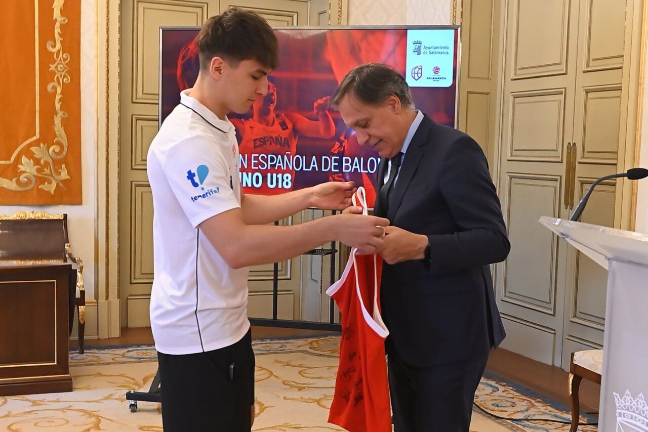 Un jugador de baloncesto entrega una camiseta a un oficial en Salamanca