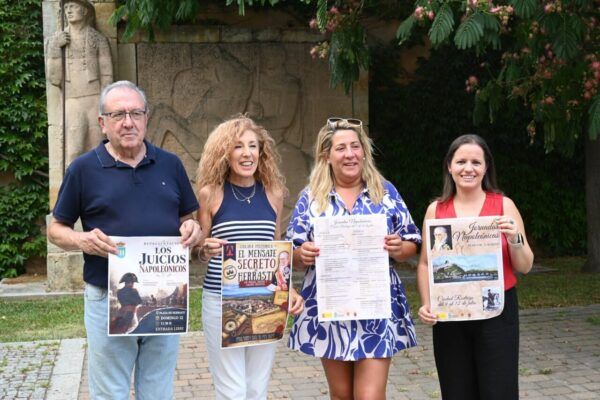 Cuatro personas sosteniendo carteles de actividades en homenaje a Herrasti