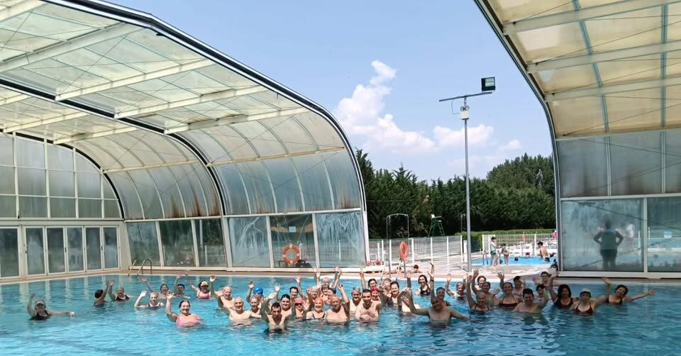 Grupo de personas en una piscina durante actividades deportivas de verano