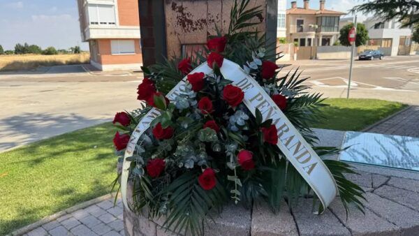 Monumento conmemorativo en Peñaranda de Bracamonte con flores rojas
