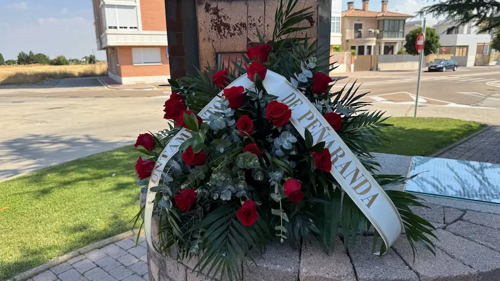 Monumento conmemorativo en Peñaranda de Bracamonte con flores rojas
