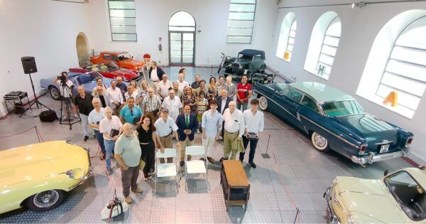 Grupo de personas en el Museo de Historia de la Automoción de Salamanca con vehículos clásicos.