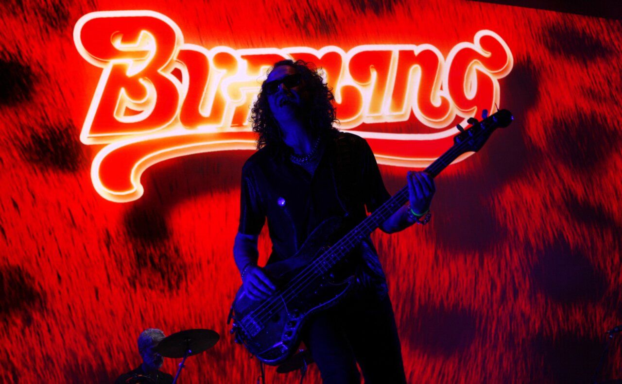 Músico de Burning tocando el bajo en un concierto en Gredos