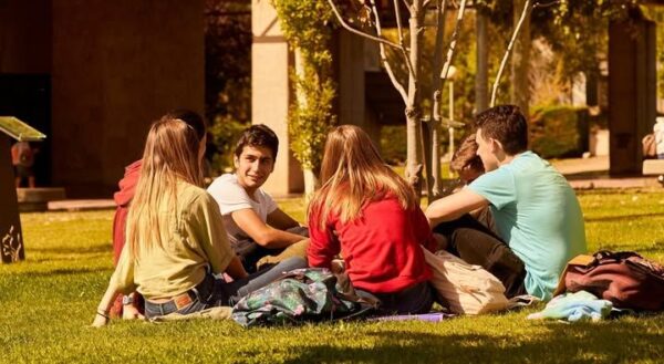 Grupo de estudiantes reunidos en un campus universitario al aire libre