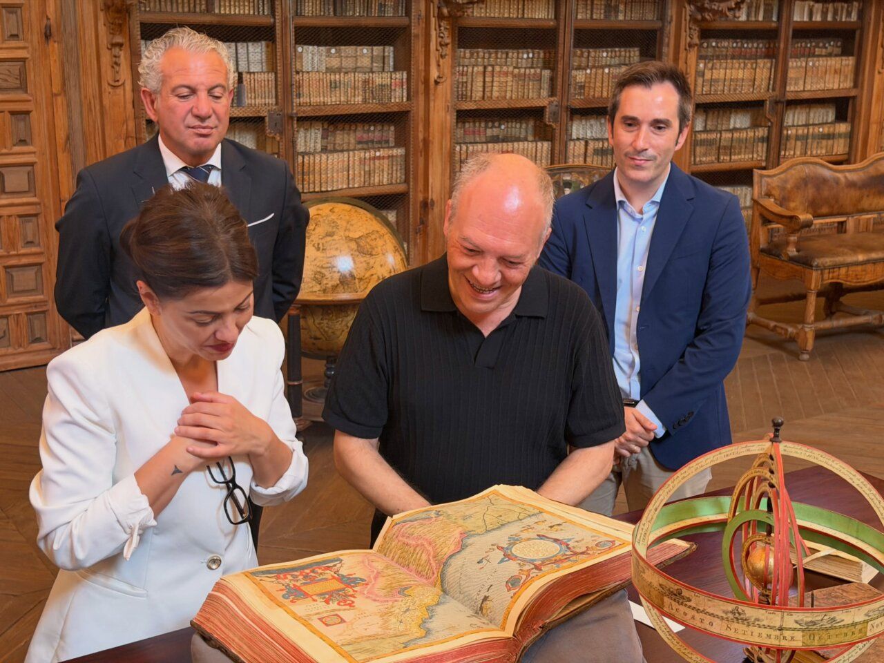 Ministra y delegados en la Universidad de Salamanca revisando un libro antiguo