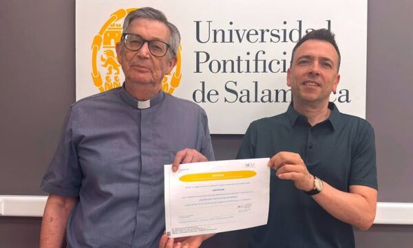 Dos hombres sosteniendo un certificado en la Universidad Pontificia de Salamanca