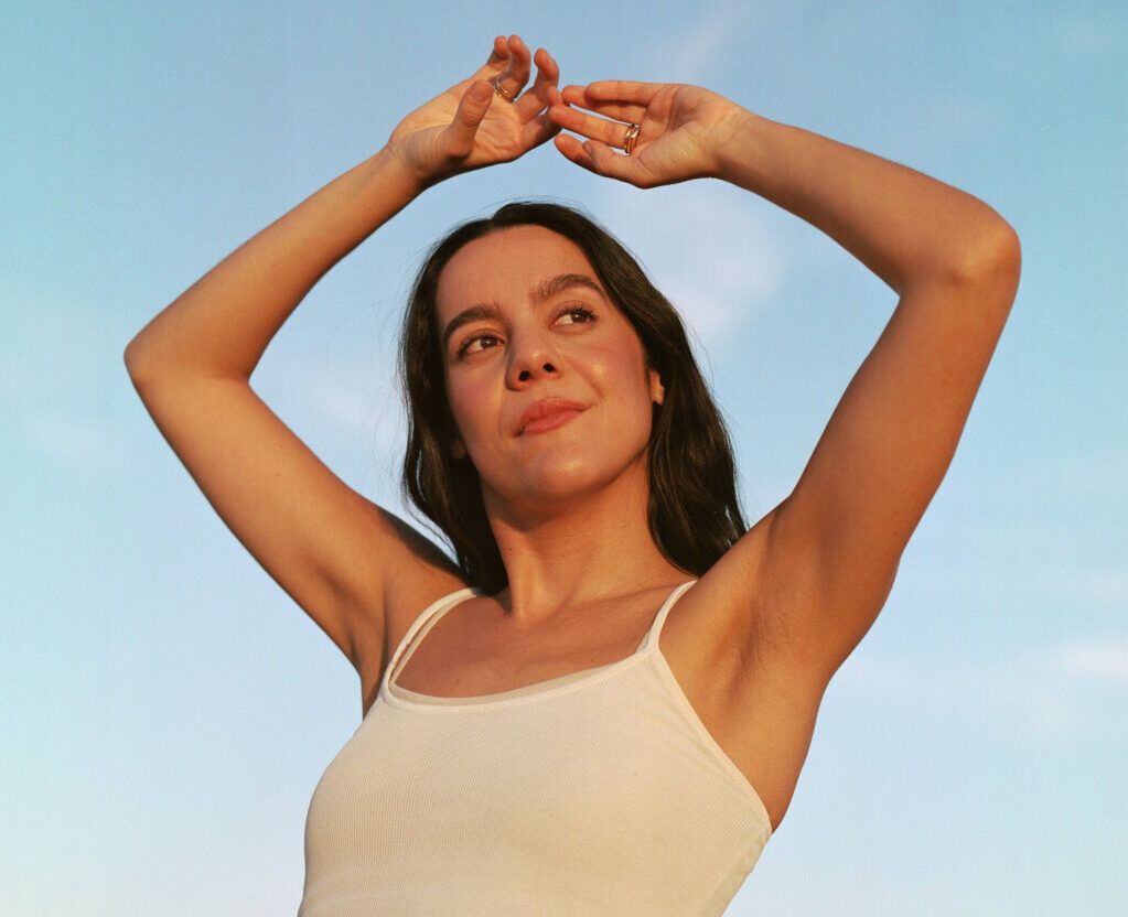 Valeria Castro posando al aire libre con fondo azul