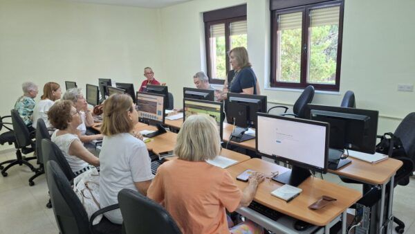 Grupo de personas mayores aprendiendo sobre tecnología en un aula