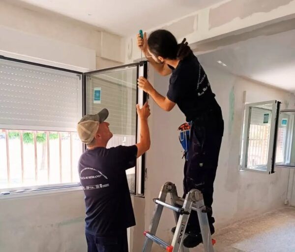 Personas trabajando en la instalación de ventanas en un programa de empleo