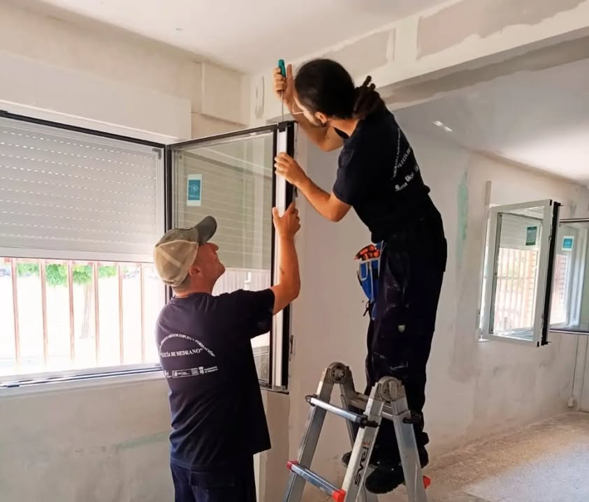 Personas trabajando en la instalación de ventanas en un programa de empleo