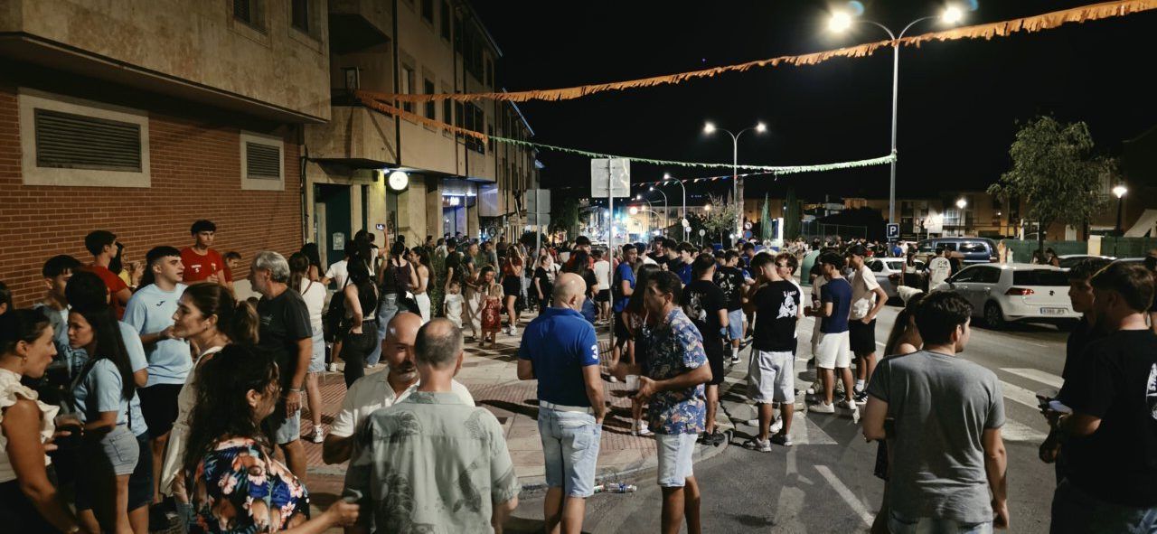 Gente celebrando la cuelga de banderines en Villamayor por la noche