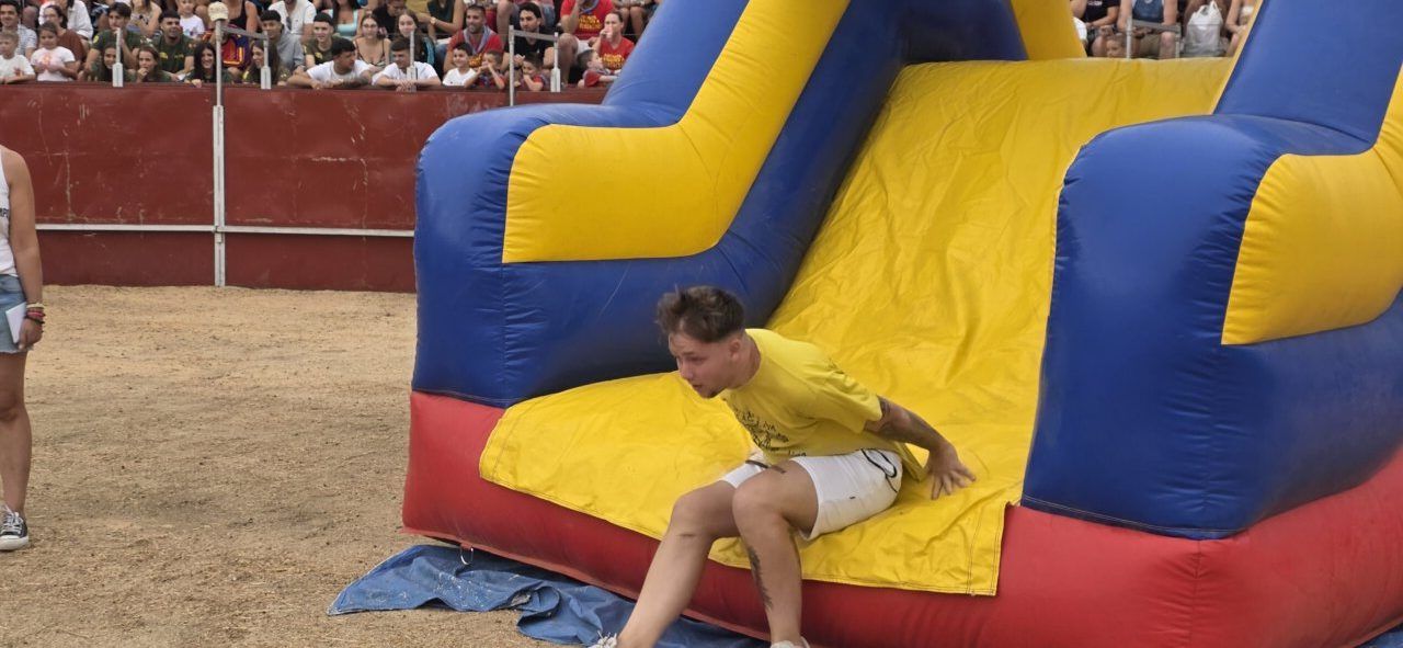 Participante deslizándose en un tobogán inflable durante las fiestas de San Roque.