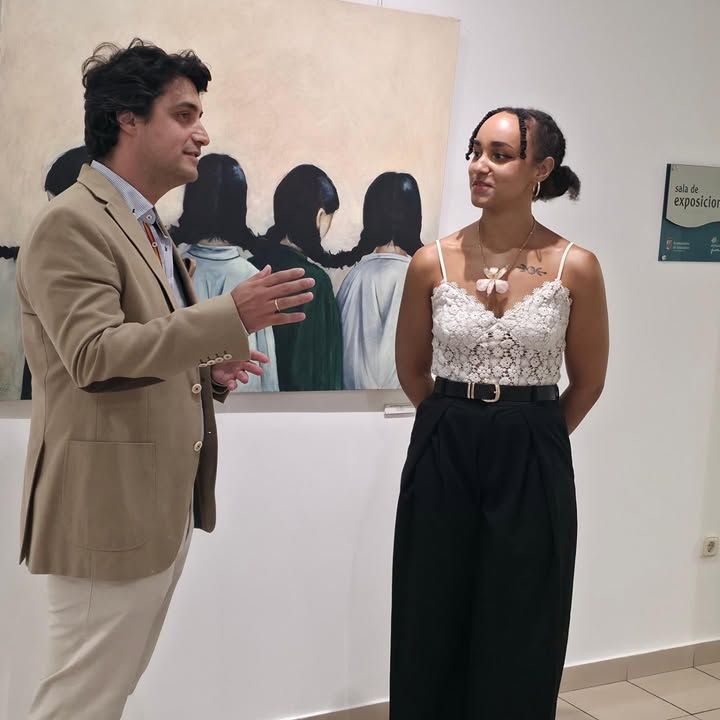 Inauguración de exposición en el Centro Joven con dos personas conversando