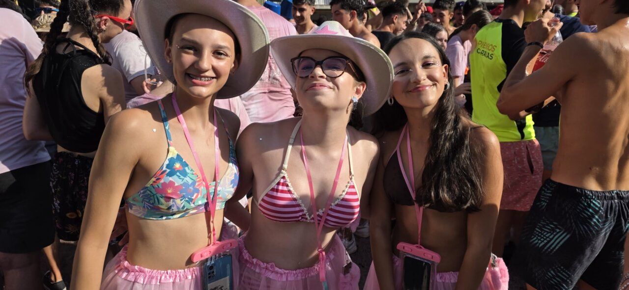 Tres jóvenes sonrientes en el chupinazo de Guijuelo, vestidas con ropa de fiesta